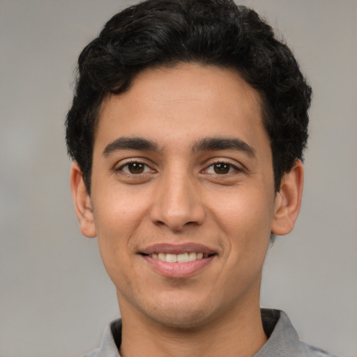 Joyful latino young-adult male with short  black hair and brown eyes