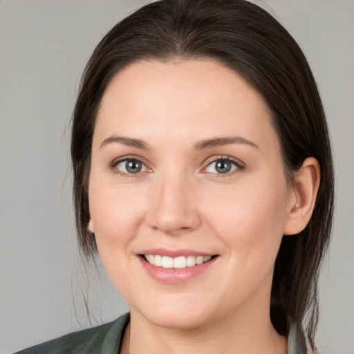 Joyful white young-adult female with medium  brown hair and grey eyes