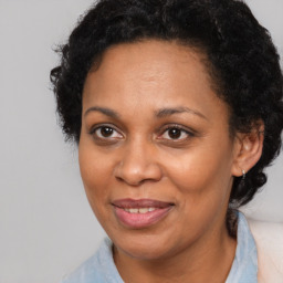 Joyful black adult female with medium  brown hair and brown eyes