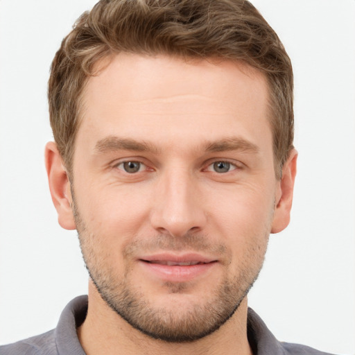 Joyful white young-adult male with short  brown hair and grey eyes