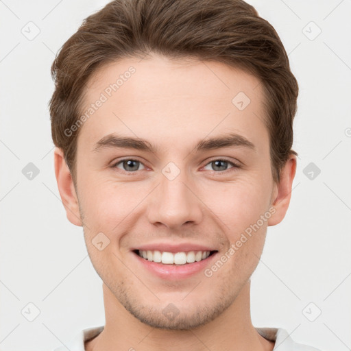 Joyful white young-adult male with short  brown hair and grey eyes