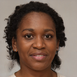 Joyful black adult female with medium  brown hair and brown eyes