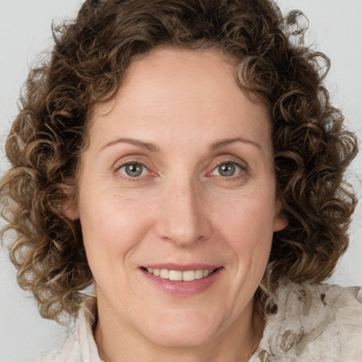 Joyful white adult female with medium  brown hair and green eyes