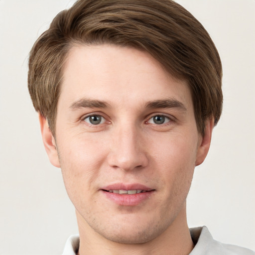 Joyful white young-adult male with short  brown hair and grey eyes