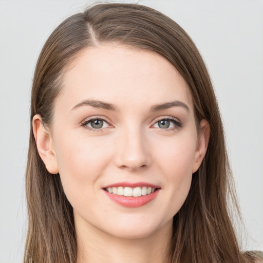 Joyful white young-adult female with long  brown hair and grey eyes