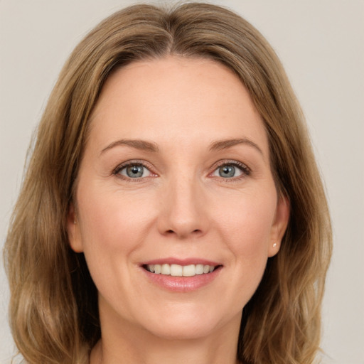 Joyful white adult female with medium  brown hair and green eyes