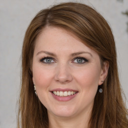 Joyful white young-adult female with long  brown hair and grey eyes