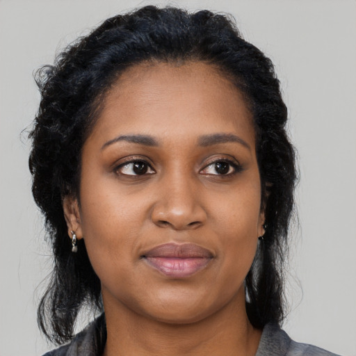 Joyful black young-adult female with long  black hair and brown eyes