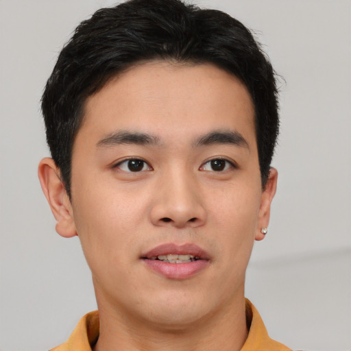 Joyful asian young-adult male with short  brown hair and brown eyes