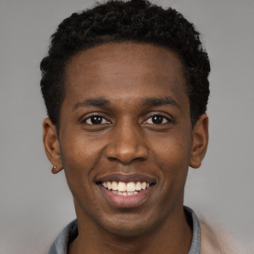 Joyful black young-adult male with short  black hair and brown eyes
