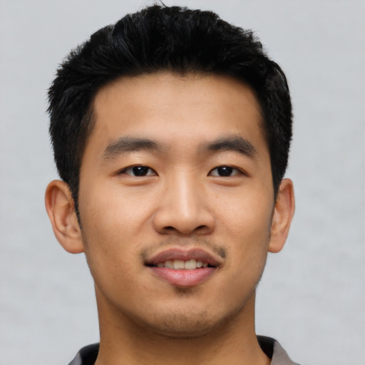Joyful asian young-adult male with short  black hair and brown eyes