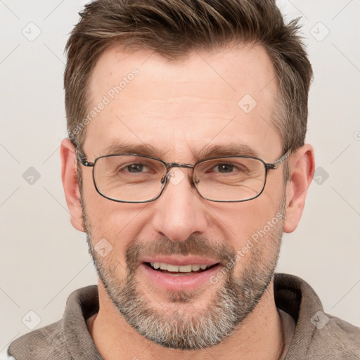 Joyful white adult male with short  brown hair and grey eyes