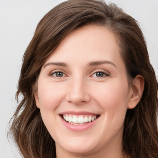 Joyful white young-adult female with long  brown hair and grey eyes