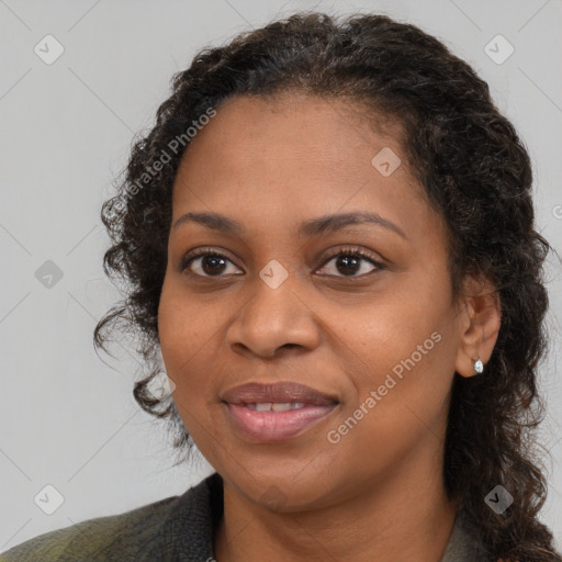 Joyful black adult female with long  brown hair and brown eyes