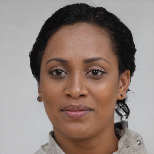 Joyful black adult female with short  brown hair and brown eyes