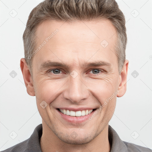 Joyful white adult male with short  brown hair and grey eyes