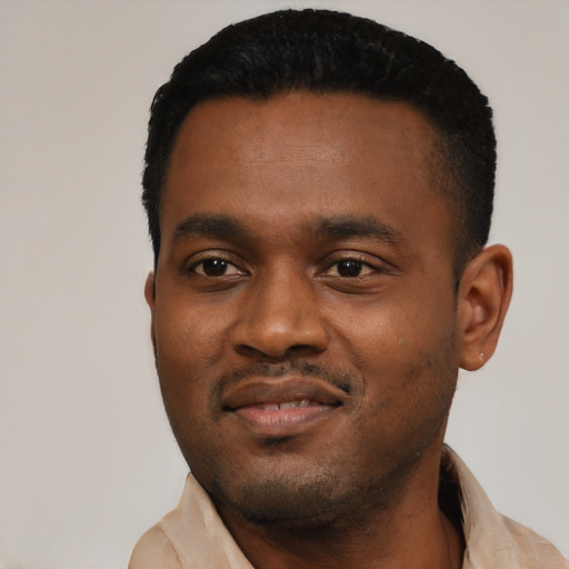 Joyful black young-adult male with short  black hair and brown eyes