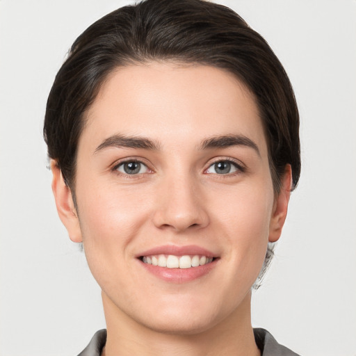 Joyful white young-adult female with short  brown hair and grey eyes