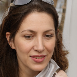 Joyful white adult female with long  brown hair and brown eyes