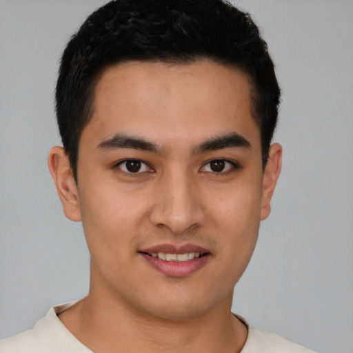 Joyful latino young-adult male with short  brown hair and brown eyes