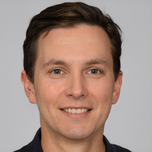 Joyful white adult male with short  brown hair and grey eyes