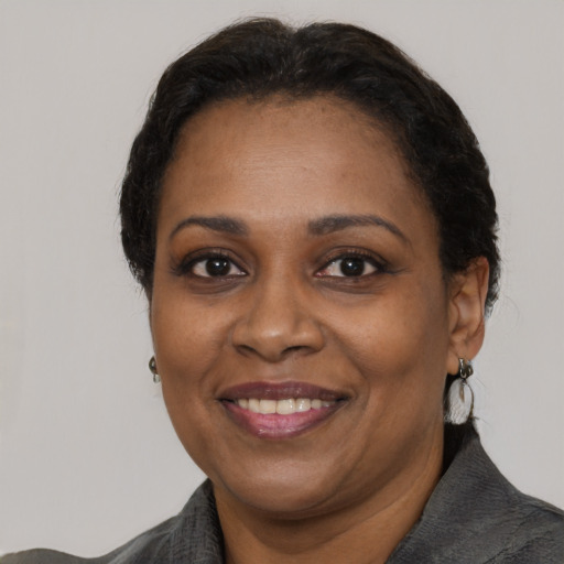 Joyful black adult female with medium  black hair and brown eyes