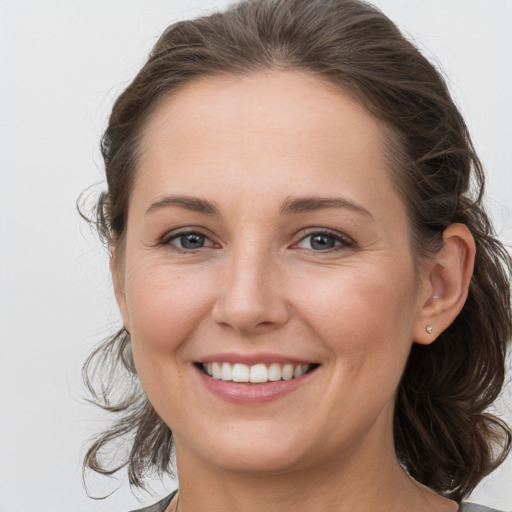 Joyful white young-adult female with medium  brown hair and grey eyes