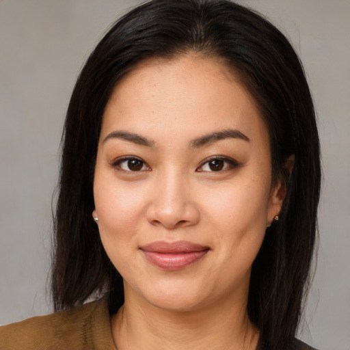 Joyful latino young-adult female with medium  brown hair and brown eyes