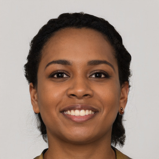 Joyful black young-adult female with short  black hair and brown eyes