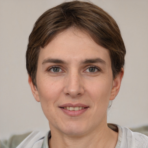 Joyful white young-adult female with short  brown hair and grey eyes