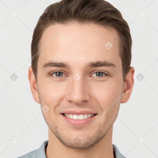 Joyful white young-adult male with short  brown hair and grey eyes