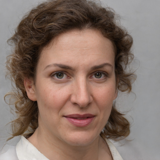 Joyful white adult female with medium  brown hair and blue eyes