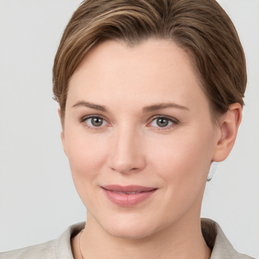 Joyful white young-adult female with short  brown hair and grey eyes