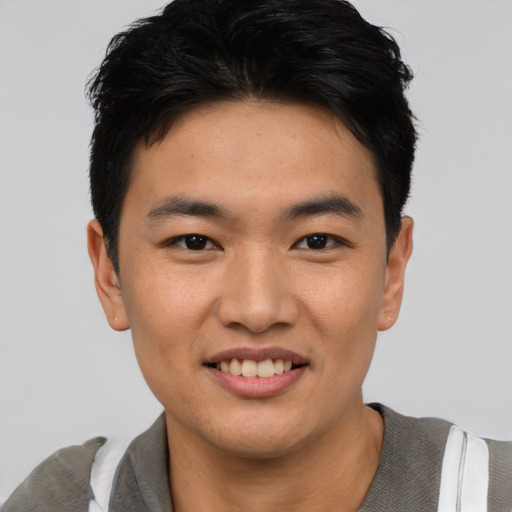 Joyful asian young-adult male with short  black hair and brown eyes