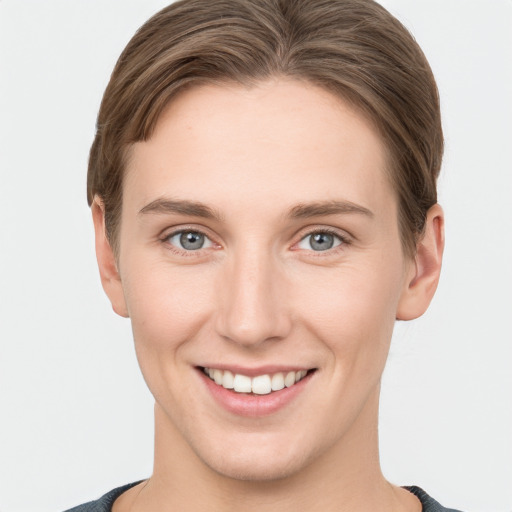 Joyful white young-adult female with short  brown hair and grey eyes