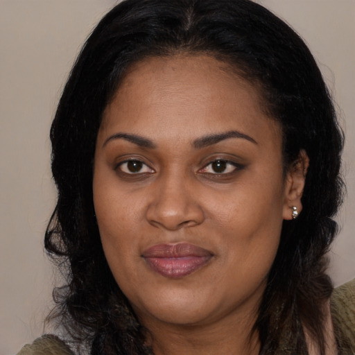 Joyful black young-adult female with long  brown hair and brown eyes