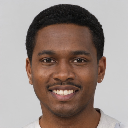 Joyful black young-adult male with short  black hair and brown eyes