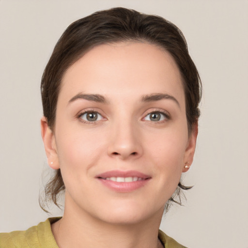 Joyful white young-adult female with short  brown hair and grey eyes