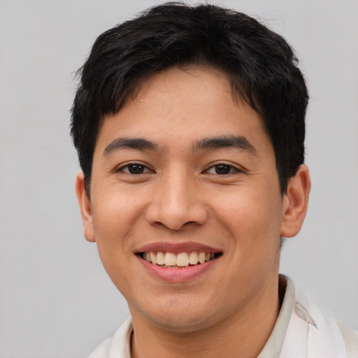 Joyful asian young-adult male with short  brown hair and brown eyes