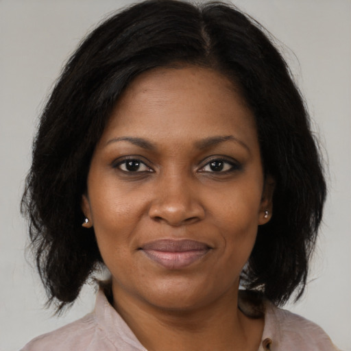 Joyful black adult female with medium  brown hair and brown eyes