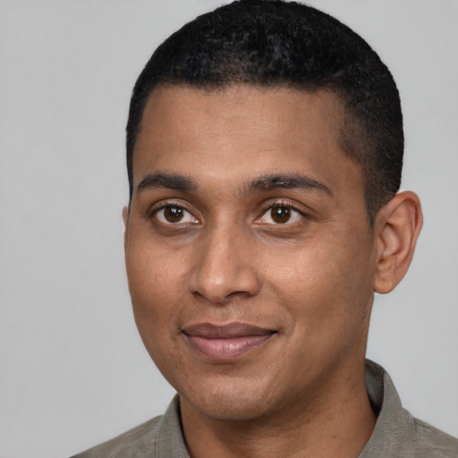 Joyful latino young-adult male with short  black hair and brown eyes