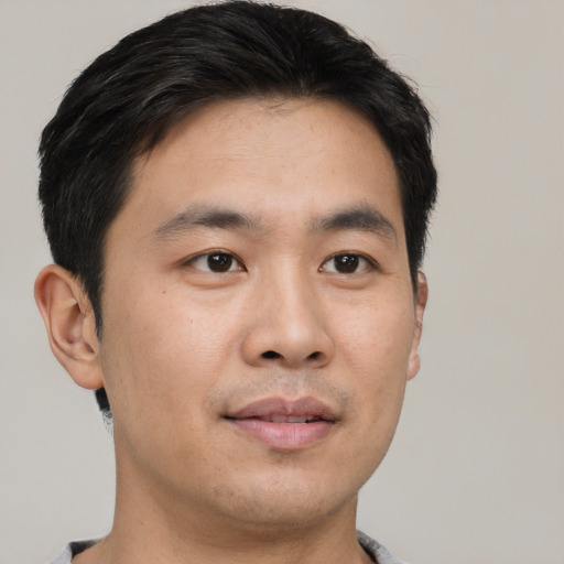 Joyful asian young-adult male with short  black hair and brown eyes
