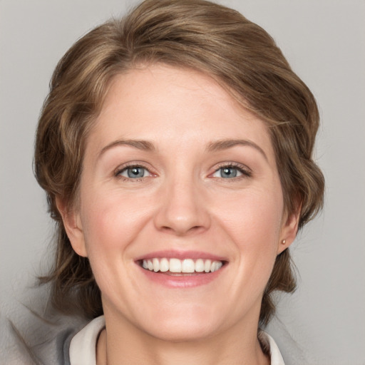 Joyful white adult female with medium  brown hair and green eyes