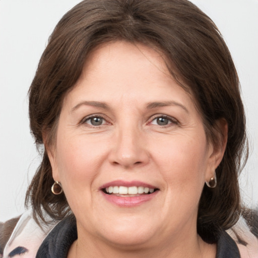 Joyful white adult female with medium  brown hair and grey eyes