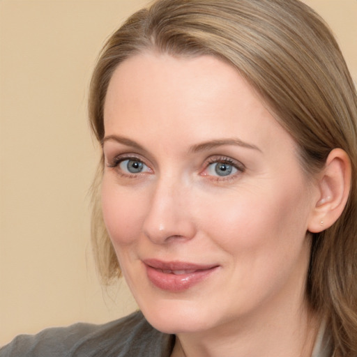 Joyful white adult female with long  brown hair and blue eyes