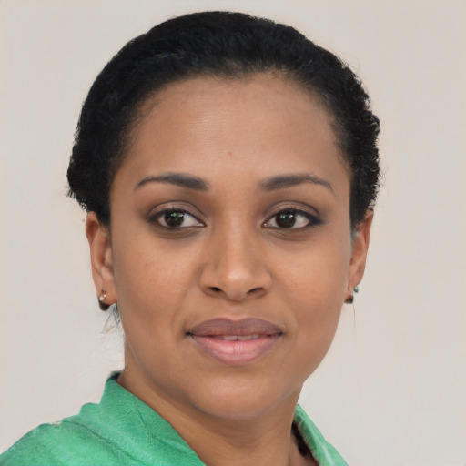 Joyful black young-adult female with short  black hair and brown eyes