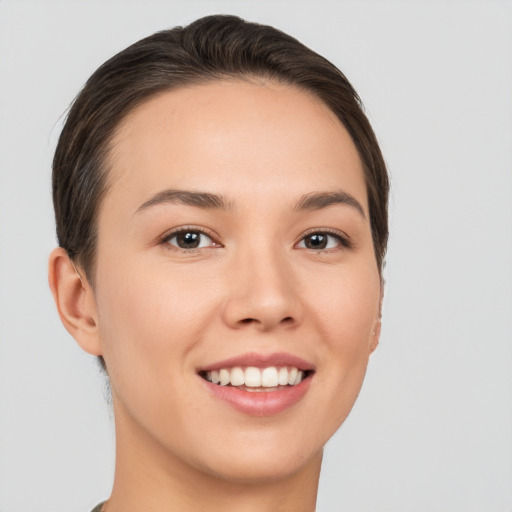 Joyful white young-adult female with short  brown hair and brown eyes