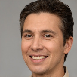 Joyful white adult male with short  brown hair and brown eyes