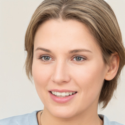 Joyful white young-adult female with medium  brown hair and grey eyes