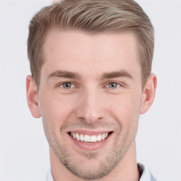 Joyful white young-adult male with short  brown hair and grey eyes